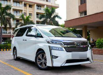 White Toyota Vellfire outside an apartment complex – Om Shakthi Travels, Chennai
